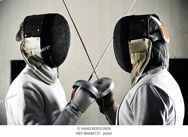 Two fencers face to face in sports hall