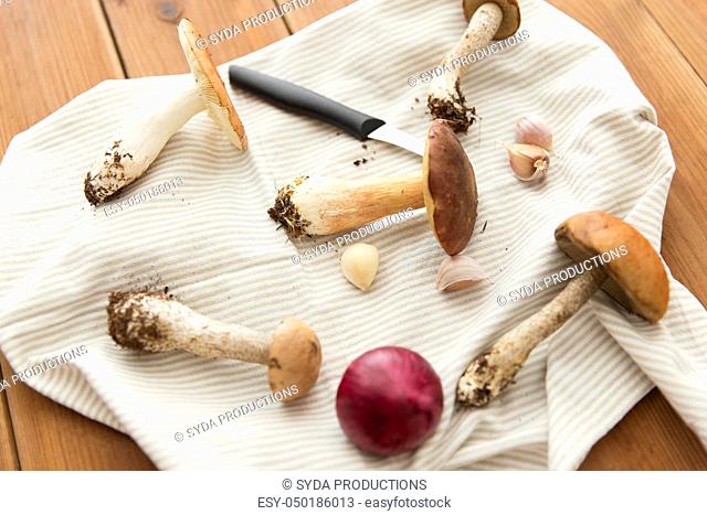 edible mushrooms, kitchen knife and towel