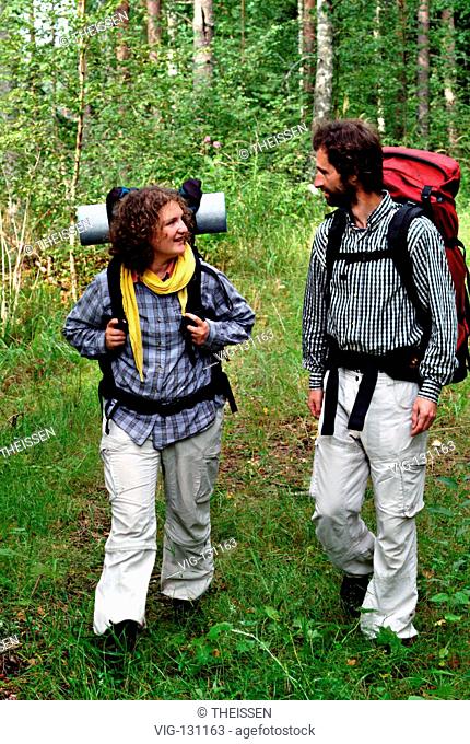 junges Paar wandert froehlich sich unterhaltend in der Natur, MR / young couple hiking cheerful talking in the nature, MR. - 01/01/2005
