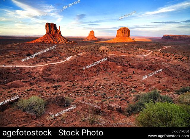 Panoramic road, gravel road in Monument Valley, prominent rocks, West Mitten Butte, East Mitten Butte, Merrick Butte on the horizon, dusk, film set, Arizona