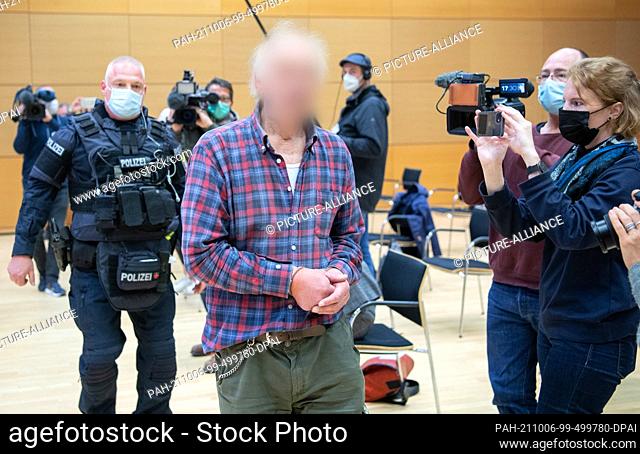 06 October 2021, Hessen, Hanau: The defendant is led into the courtroom by a police officer. The man is the father of the assassin of Hanau