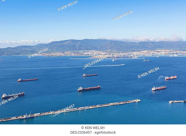 View across Gibraltar Bay, also known as Algeciras Bay, to Algeciras in Spain with cargo boats at anchor in Gibraltarian waters and the Ceuta to Algeciras ferry...