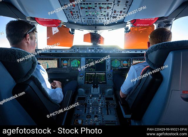 29 April 2022, Nordpol/Berlin: Michael Weyerer (l), an air force captain, and co-pilot Phillip Reipert sit in the cockpit of the Airbus A350 and steer the plane...