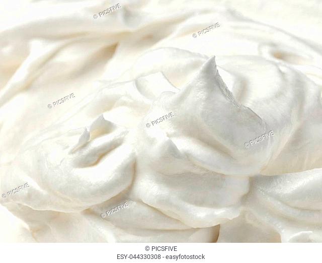 close up of a white whipped or sour cream on white background