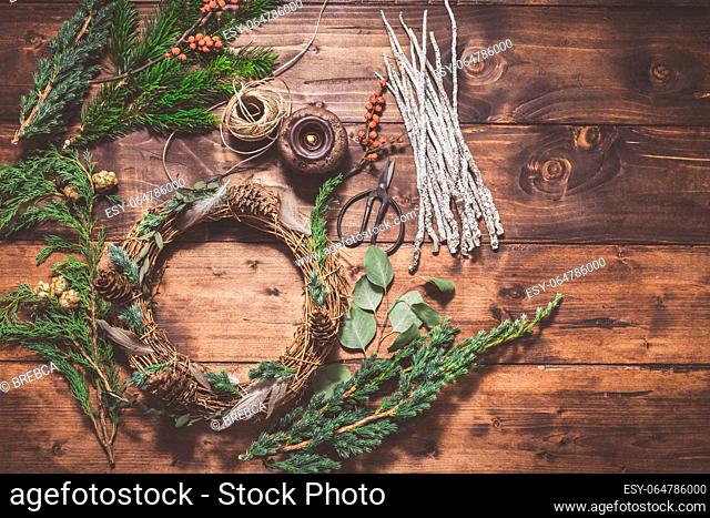 Top down view of florist's worktable. Making of festive wreath for autumn or Christmas