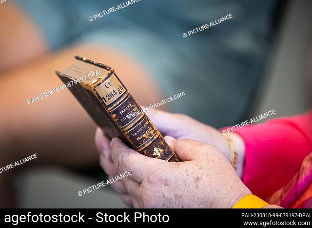 18 August 2023, Berlin: Carolyn Hollander, granddaughter of Cäcilie Holländer, holds one of two books by Cäcilie Holländer