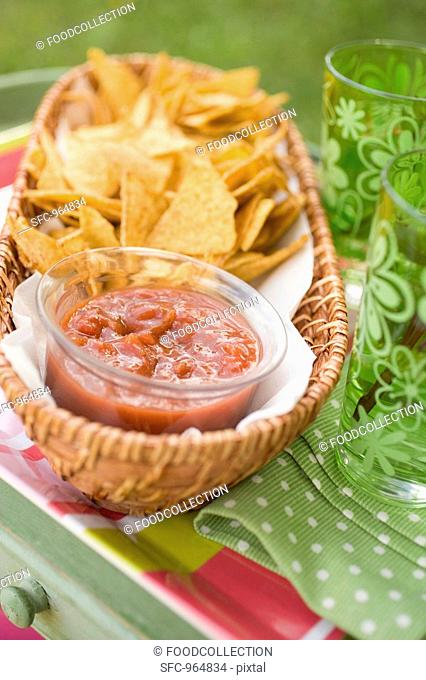 Tortilla chips and salsa on garden table