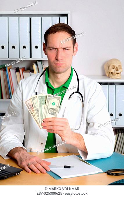 young doctor in his office with dollars is angry