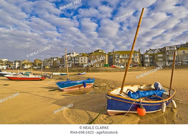 Strange cloud formation in the early morning with small Cornish fishing boats at low tide in the harbour at St. Ives, Cornwall, England, United Kingdom, Europe