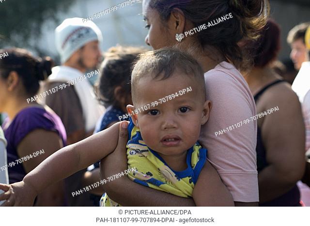 06 November 2018, Mexico, Mexiko-Stadt: A woman carries her child in her arms while she is in the emergency shelter at the ""Jesus Martinez 'Palillo"" stadium
