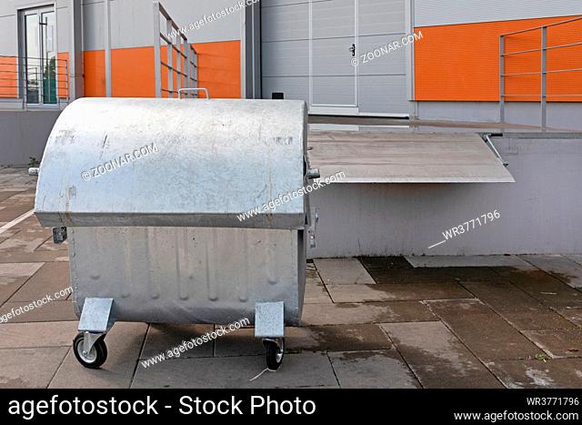 Silver Industrial Dumpster Container in Front of Warehouse