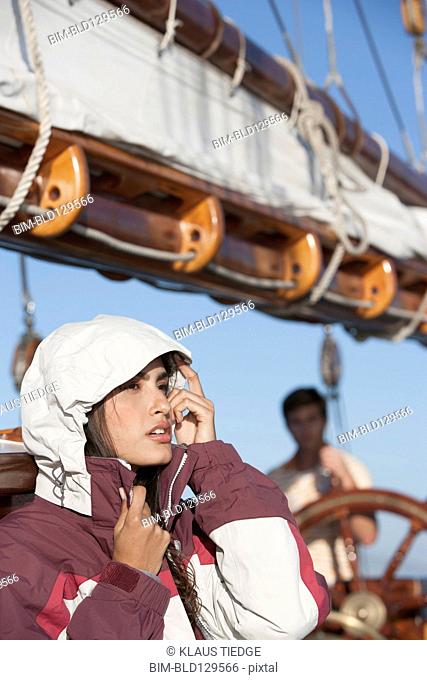 Caucasian woman wearing jacket on sailboat