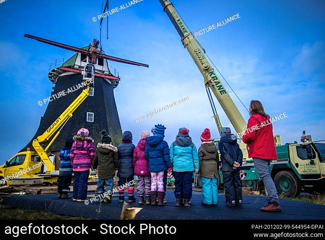 02 December 2020, Mecklenburg-Western Pomerania, Stove: Children from the local kindergarten observe the lifting of the mill cap, which weighs about 17 tons