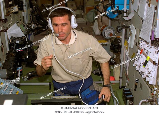 Cosmonaut Yuri I. Malenchenko, Expedition Seven mission commander, uses a communication system in the Zvezda Service Module on the International Space Station...