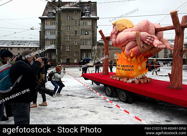 15 February 2021, North Rhine-Westphalia, Duesseldorf: A motto float with a figure meant to represent US President-elect Donald Trump grilling over a fire is...