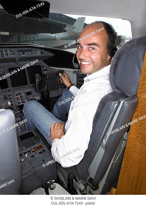 Male pilot in cockpit of private jet