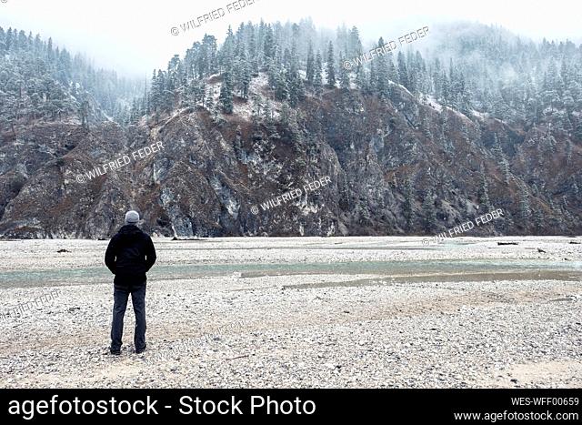 Hiker looking at mountains in winter vacation, Vorderriss, Bavaria, Germany