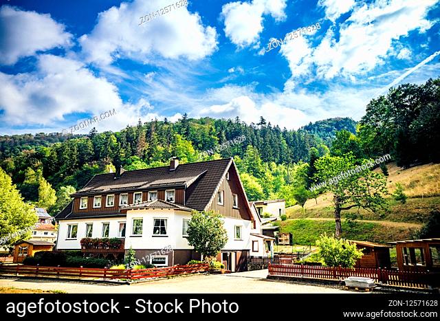 Idyllic house in the German alps with green forest in the background under a blue sky in the summer