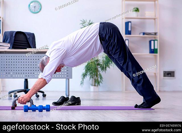 Aged employee doing physical exercises during break