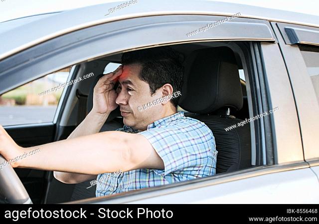 A driver with a headache in traffic, fatigued driver stuck in traffic, concept of a fatigued man in his car, stressed out