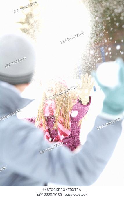 Image of attractive young woman flinging the snowball and having fun