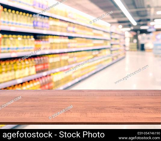 Brown wooden board empty table in front of blurred background. Perspective dark wood over blur in supermarket - can be used for display or montage your products