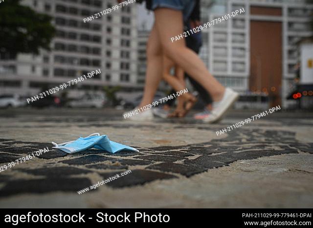 28 October 2021, Brazil, Rio De Janeiro: A mouth-nose protector is seen on the sidewalk at Ipanema beach. In the Brazilian state of Rio de Janeiro