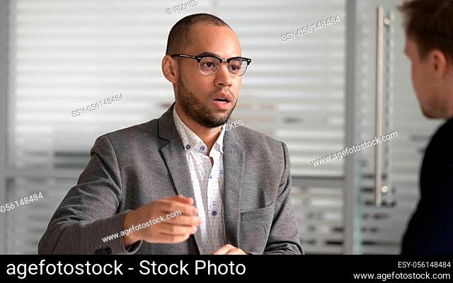 Head shot focused african american businessman in formal wear coming to agreement with partner. Serious mixed race applicant presenting himself on dream job...