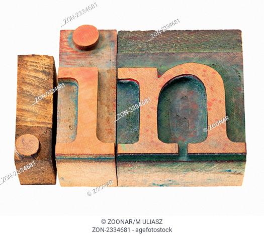 dot in - internet domain for India in vintage wooden letterpress printing blocks, stained by color inks, isolated on white