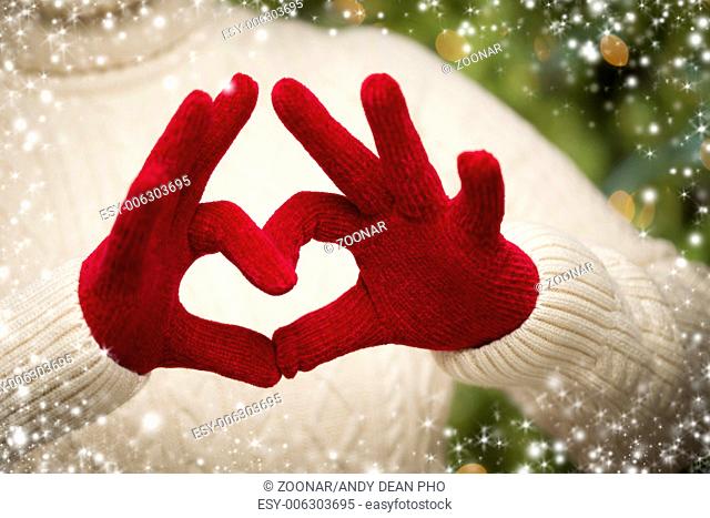 Woman Wearing Red Mittens Holding Out a Heart Hand Sign