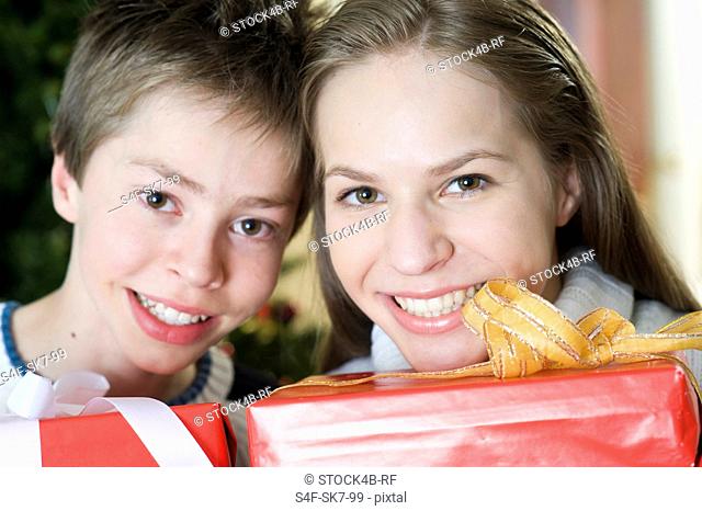 Happy brother and sister with Christmas presents, Munich, Bavaria, Germany