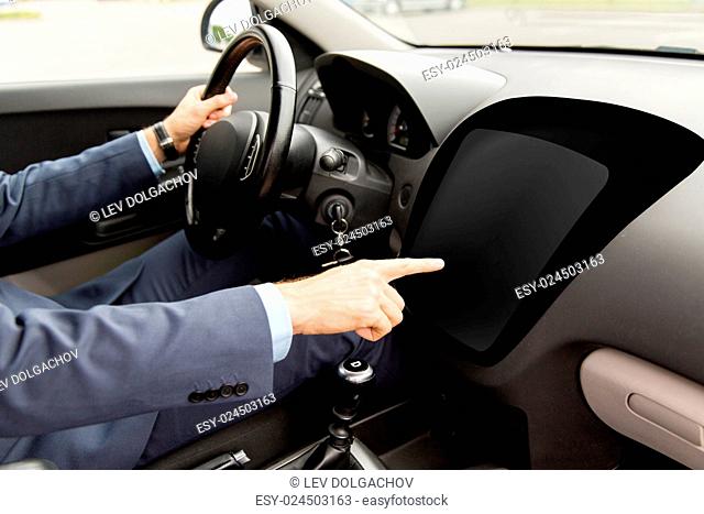 transport, business, modern technology and people concept - close up of man driving car and pointing finger to blank on-board computer screen