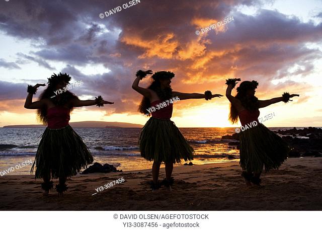 Three hula dancers at sunset at Palauea Beach, Maui, Hawaii