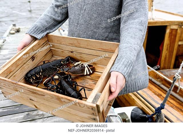 Woman carrying lobsters, close-up