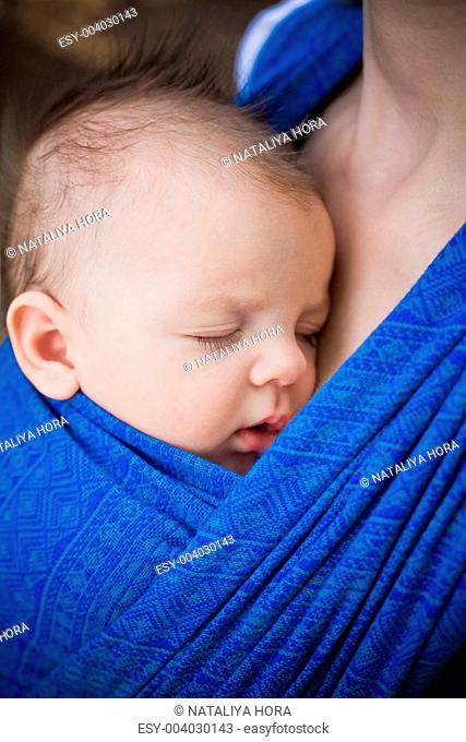sleeping newborn baby in the sling