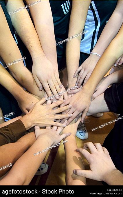 Female Team Mates Show Solidarity Prior to high School Volleyball Match by holding hands