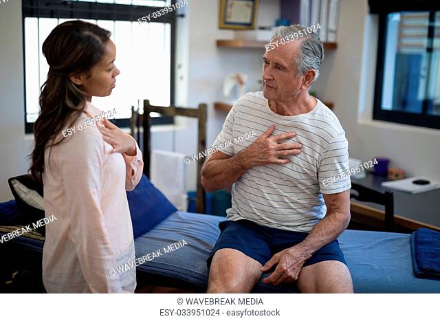 Female therapist talking with senior male patient