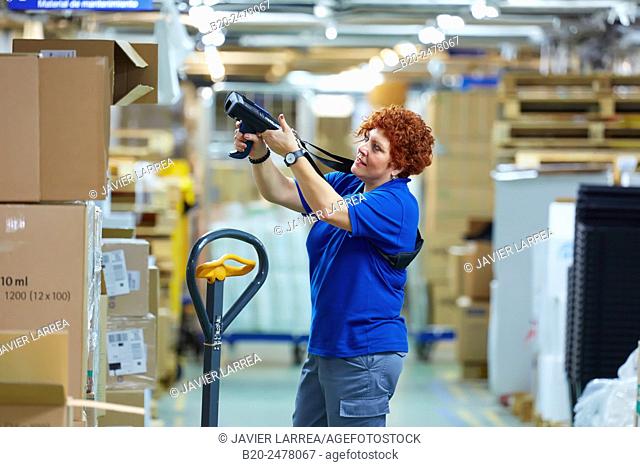Woman scanning boxes with bar codes reader in hospital warehouse, Hospital Donostia, San Sebastian, Basque Country, Spain