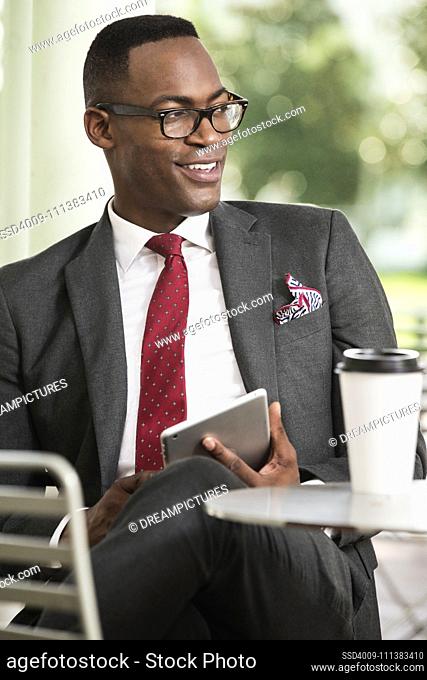 Black businessman using digital tablet at cafe