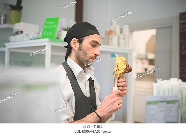 Waiter serving ice cream cone in cafe