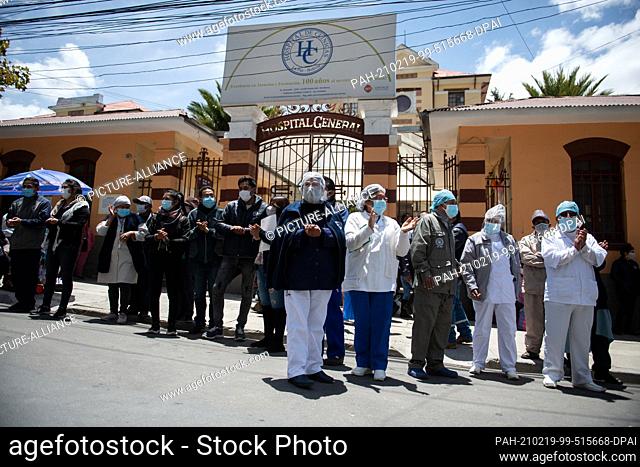 19 February 2021, Bolivia, La Paz: Health workers wearing masks protest in front of the Hospital de Clinicas demanding payment of their wages