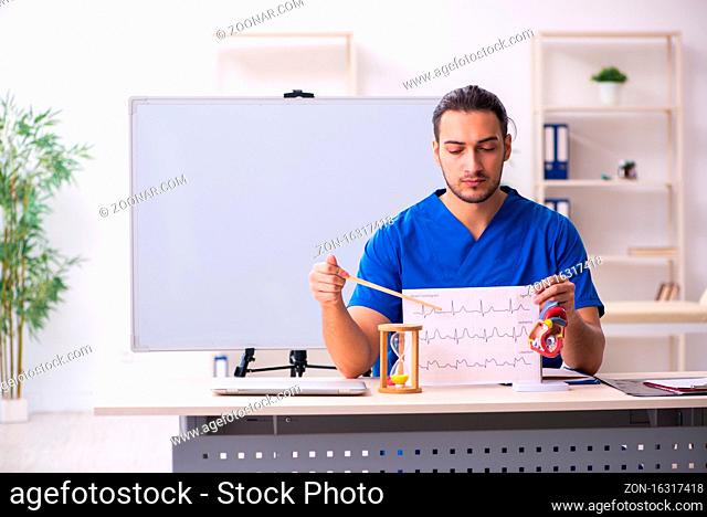 Male doctor teacher cardiologist in front of whiteboard