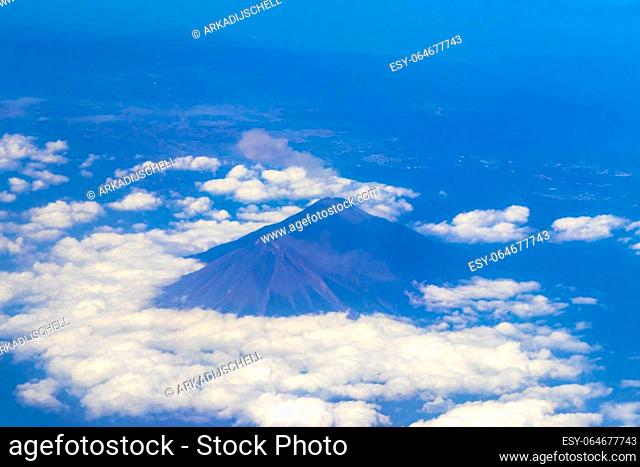 Flying by plane over Mexico with view of volcanoes mountains and clouds