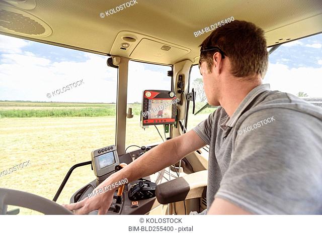 Caucasian man driving tractor on farm