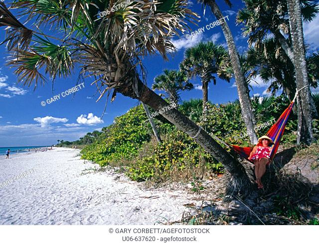 Senior woman lounging in a hammock in palms at Casperson beach in SW Florida (USA)
