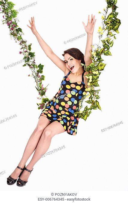 Beautiful girl swinging on flower swing. Isolated