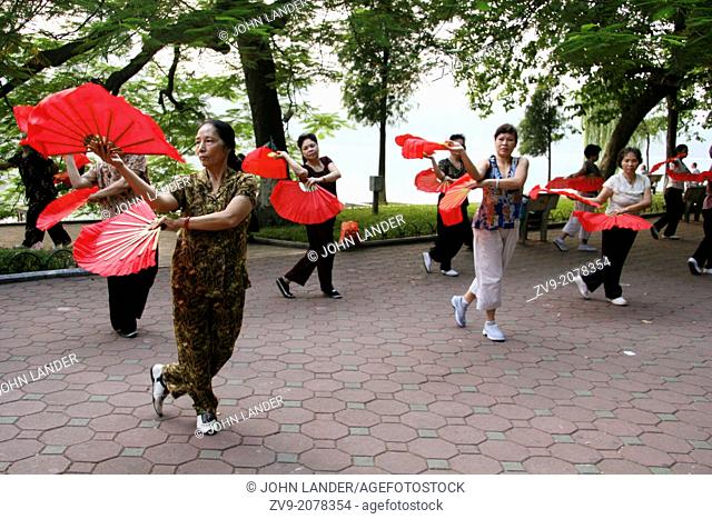 Early morning along the shores of Hoan Kiem Lake fan dancing is popular with Vietnamese ladies. Hoan Kiem Lake is right in the historical center of the city and...