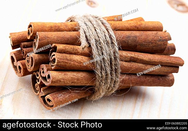 Tied cinnamon sticks on white background