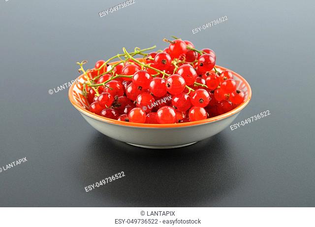 Red currant with bowl on black