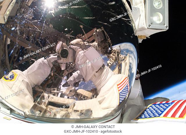 Expedition 35 Flight Engineers Chris Cassidy takes a self portrait, as he and Tom Marshburn (seen partially in Cassidy's helmet visor) accomplished a space walk...
